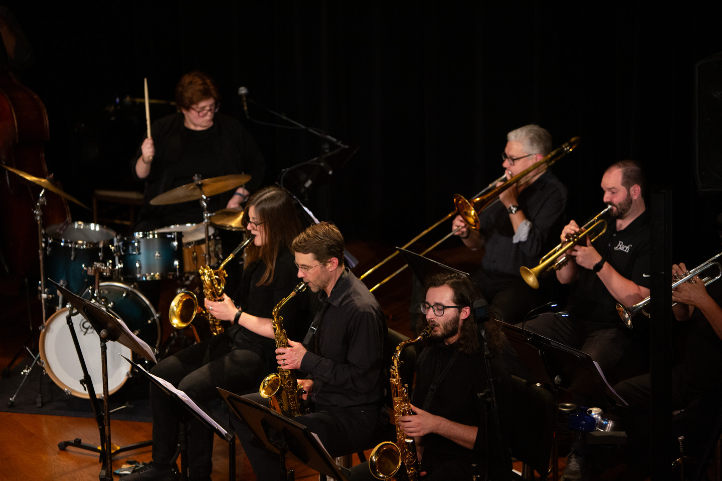 The horn section mid-song — saxophones out front with trombone and trumpets behind.